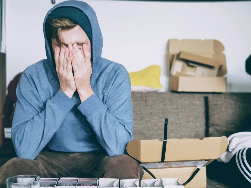 Stressed man in room with open boxes. 