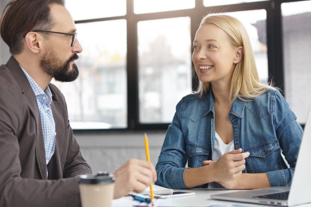 A man and woman meeting to discuss their ideas and laugh