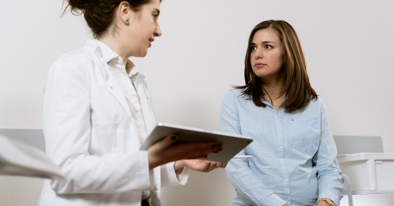doctor holding tablet and talking to patient