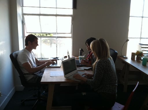 Carlos and coworkers sharing a desk in San Francisco