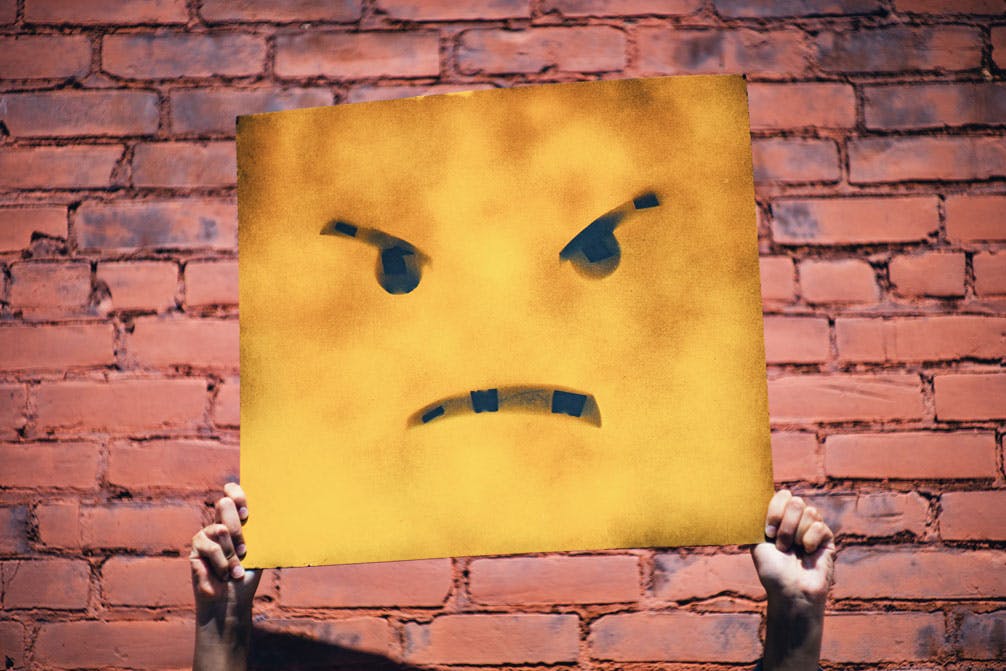 Angry face on yellow board