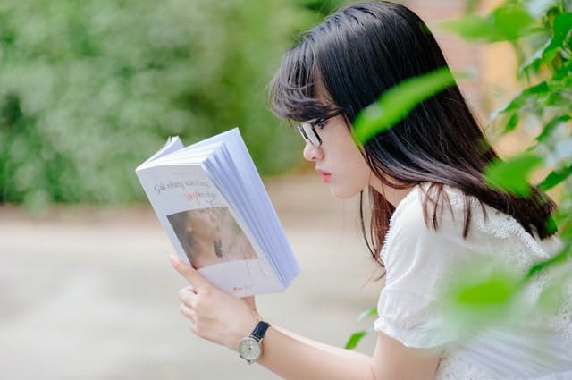 Side profile of girl reading book