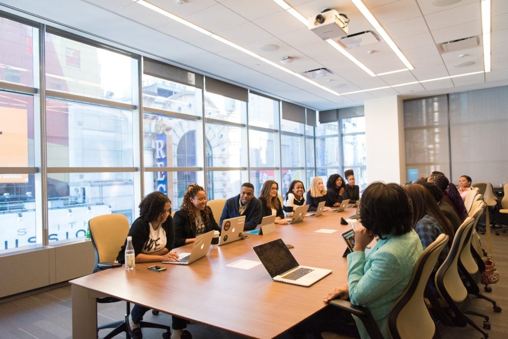 people sitting around a table with computers
