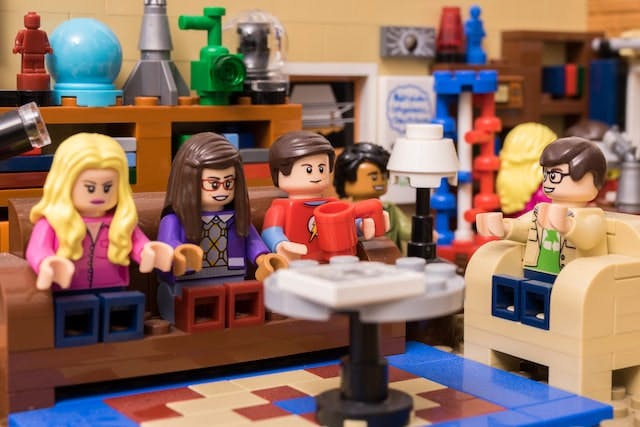 group of lego characters on a couch, next to one lego person in a chair