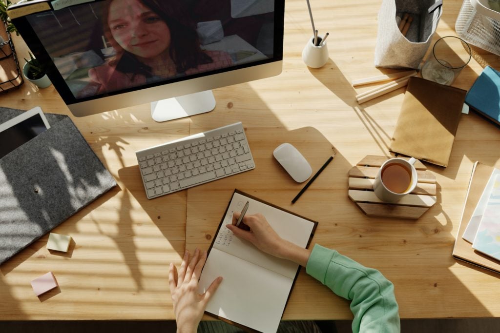 Individual studying online and taking notes