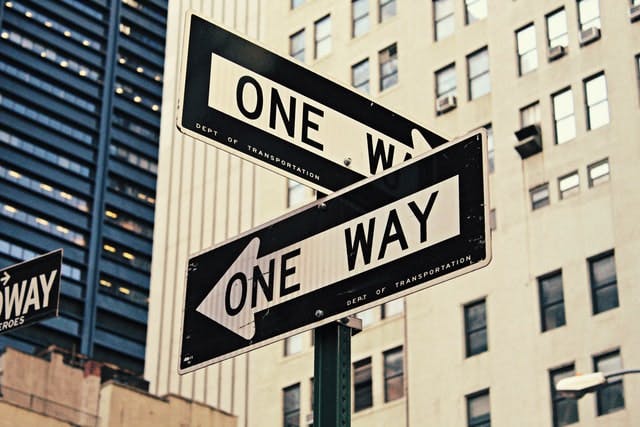 Two one way signs pointing in different directions